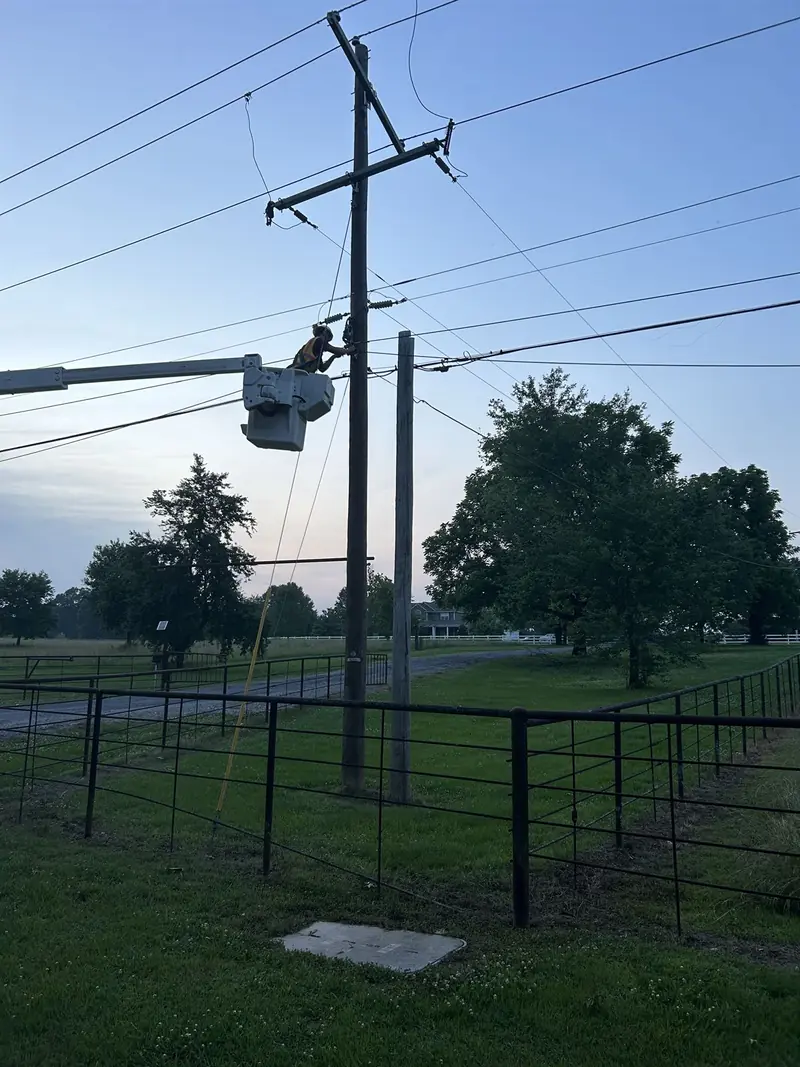 Lineman in a bucket truck working a pole line at first light