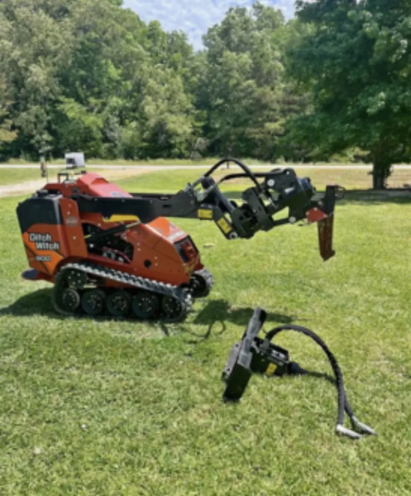 Compact tracked vibratory plow on a grass right-of-way