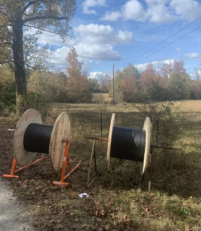 Fiber reels staged on stands at the edge of a field